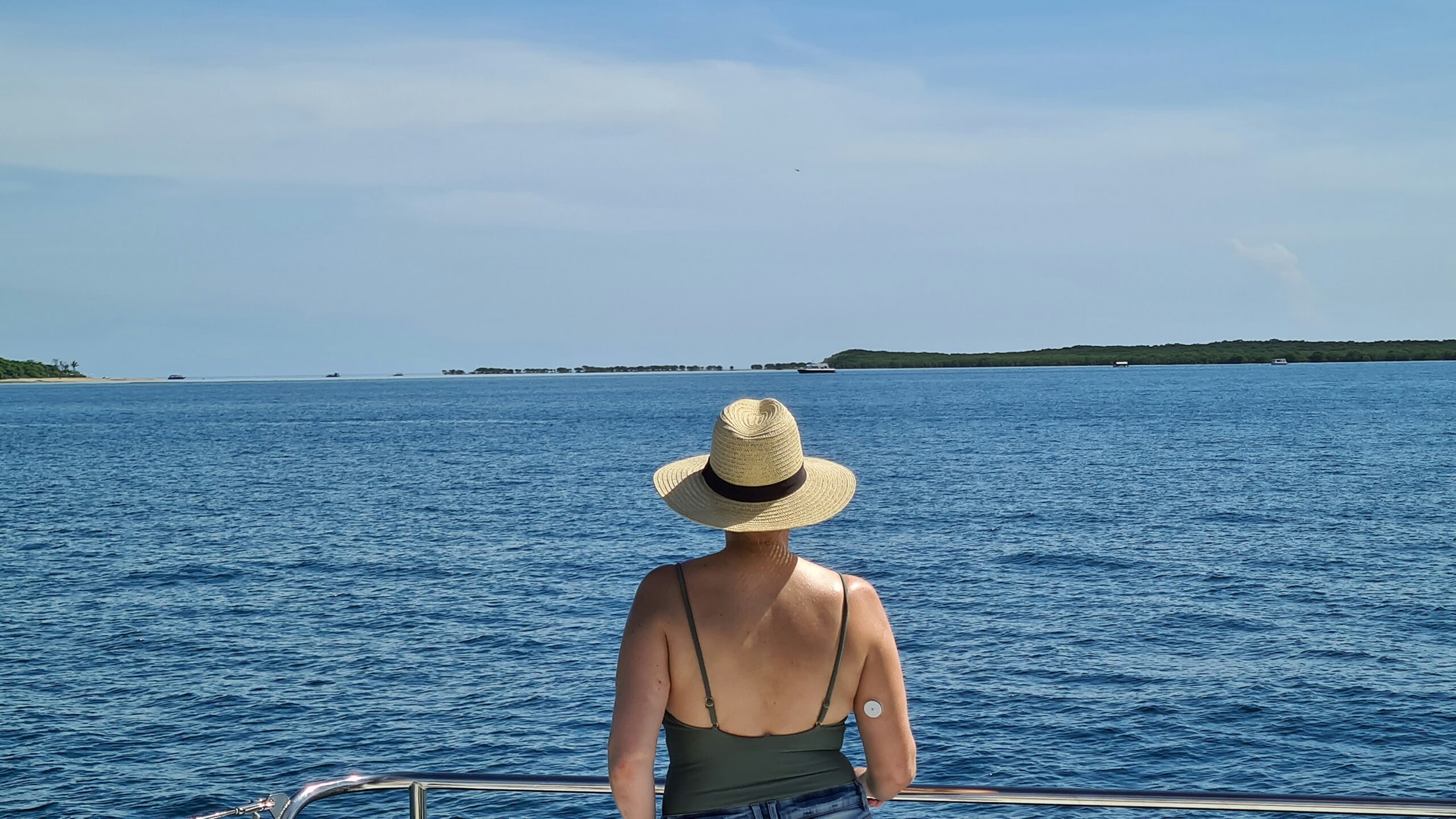 woman in brown sun hat and brown tank top sitting on boat during daytime